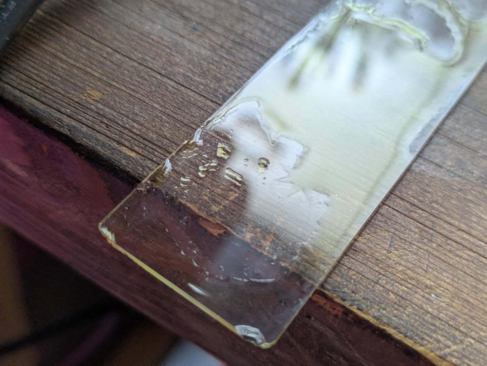 surface tension pulling the liquid into one of the etched shapes